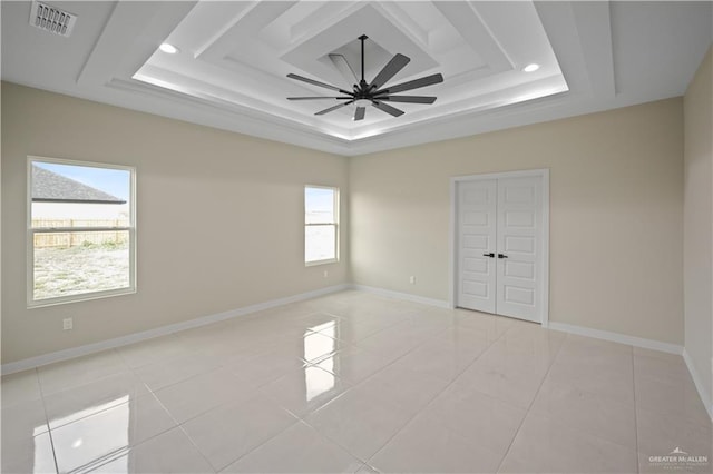 unfurnished bedroom with baseboards, visible vents, and a tray ceiling