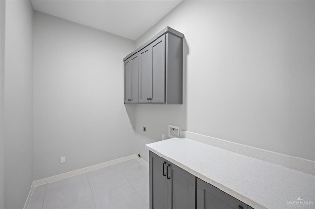 laundry room featuring light tile patterned floors, washer hookup, baseboards, cabinet space, and electric dryer hookup