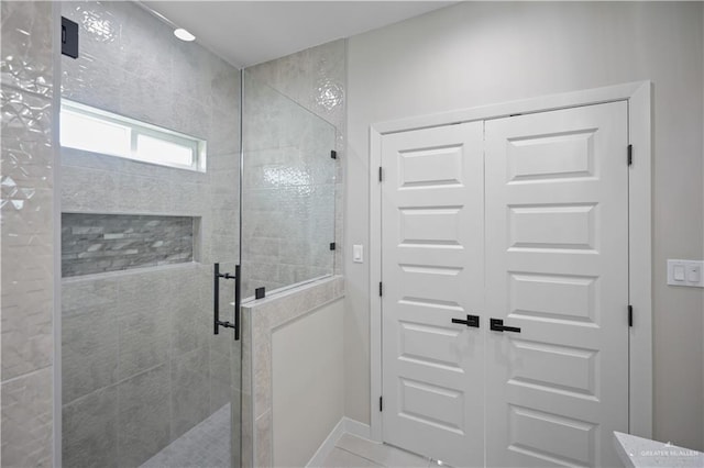 bathroom with a shower stall and baseboards