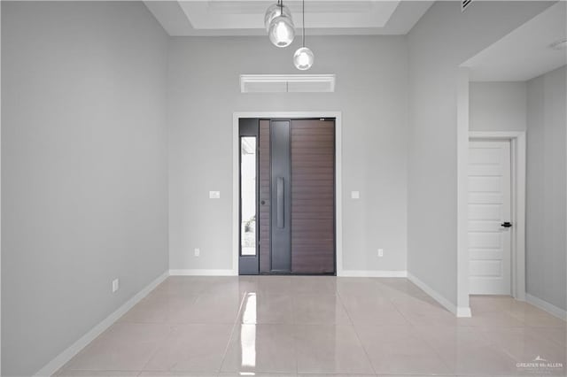 foyer with visible vents, baseboards, a raised ceiling, and light tile patterned flooring