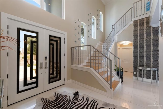 foyer with a healthy amount of sunlight, stairway, and french doors