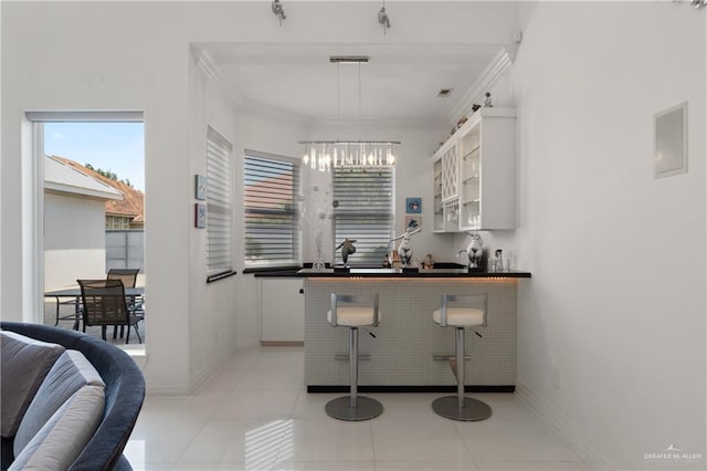 kitchen with dark countertops, a wealth of natural light, open shelves, and a notable chandelier
