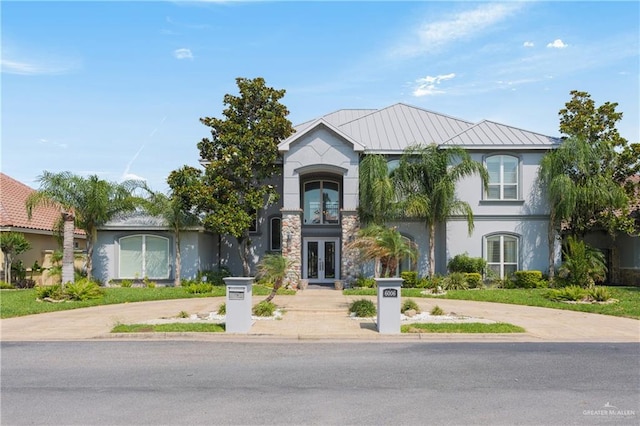 view of front of property featuring concrete driveway, french doors, and stucco siding