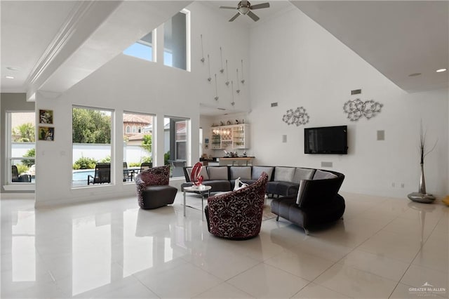 living area featuring crown molding, a high ceiling, a healthy amount of sunlight, and tile patterned flooring