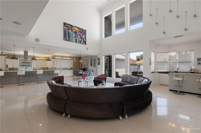 living room featuring light tile patterned floors, a high ceiling, and ornamental molding