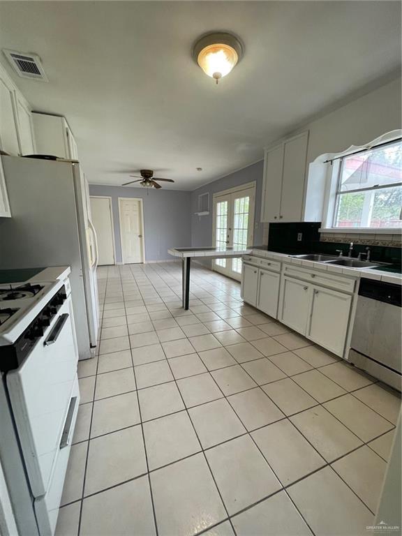 kitchen featuring dishwasher, gas range gas stove, visible vents, and white cabinets