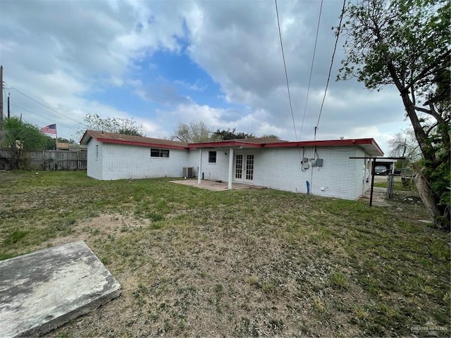 rear view of house featuring a patio area, fence, a lawn, and french doors