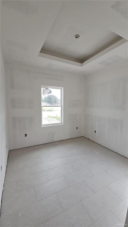 unfurnished room featuring a tray ceiling