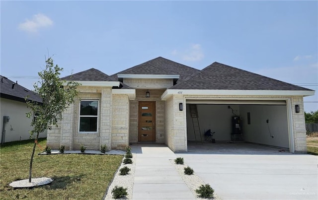 406 Zapata St, San Juan, TX 78589 - view of front of house with an attached garage, roof with shingles, concrete driveway, and secured water heater