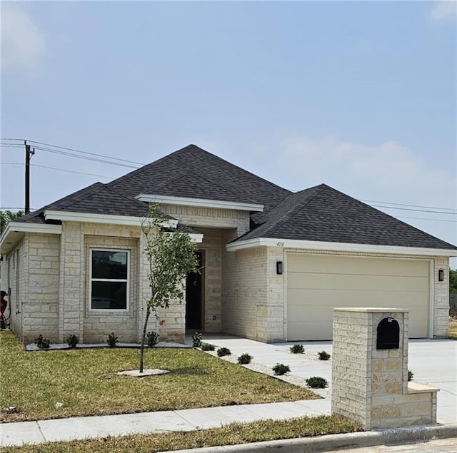 406 Zapata St, San Juan, TX 78589 - view of front facade featuring a shingled roof, an attached garage, a front yard, driveway, and stone siding
