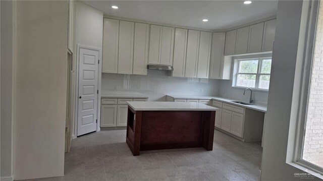 406 Zapata St, San Juan, TX 78589 - kitchen featuring a sink, under cabinet range hood, backsplash, recessed lighting, and a kitchen island