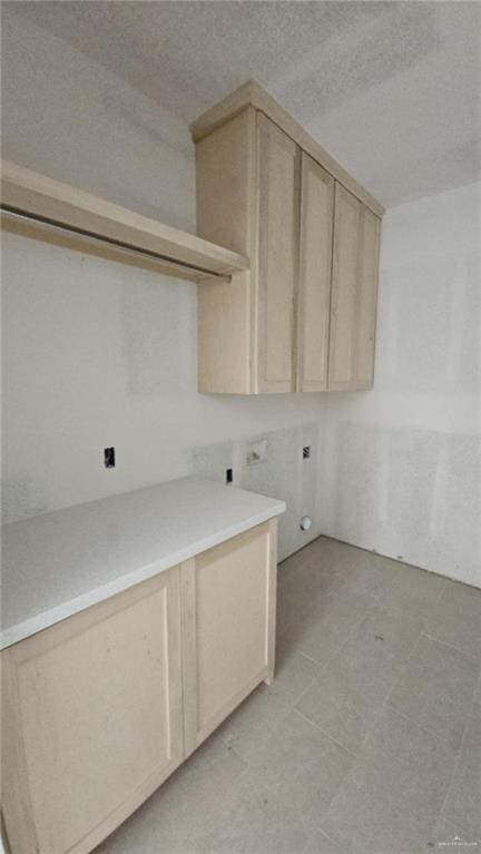 laundry area with cabinets, a textured ceiling, and hookup for an electric dryer