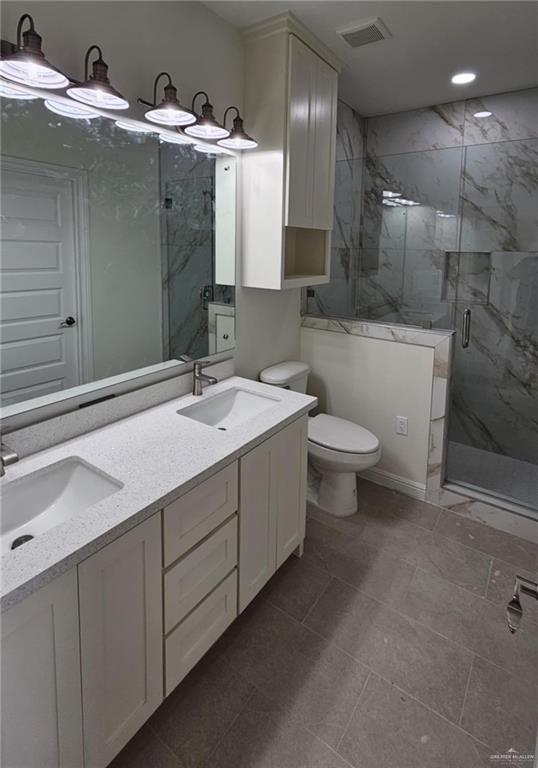 406 Zapata St, San Juan, TX 78589 - full bath with a marble finish shower, toilet, and double vanity