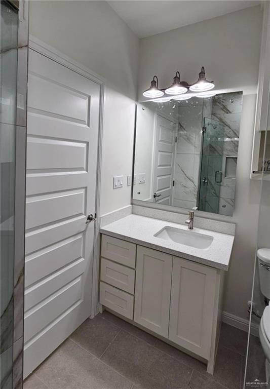 406 Zapata St, San Juan, TX 78589 - bathroom featuring a marble finish shower, toilet, vanity, baseboards, and tile patterned flooring