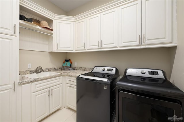 laundry area featuring sink, washer and clothes dryer, cabinets, and light tile patterned flooring