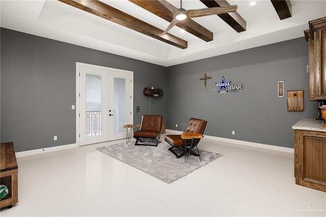 living area featuring beam ceiling and french doors