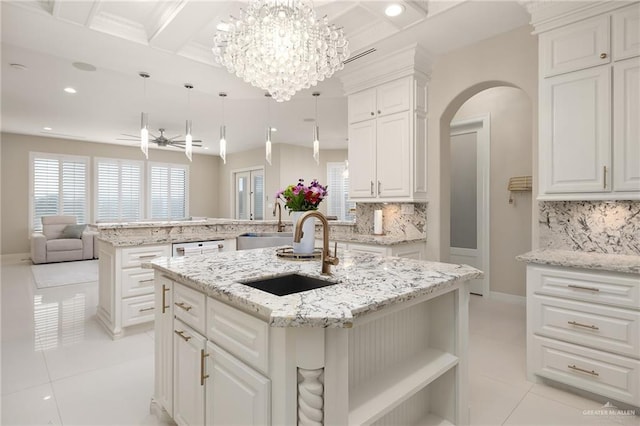 kitchen featuring pendant lighting, sink, a kitchen island with sink, white cabinets, and kitchen peninsula