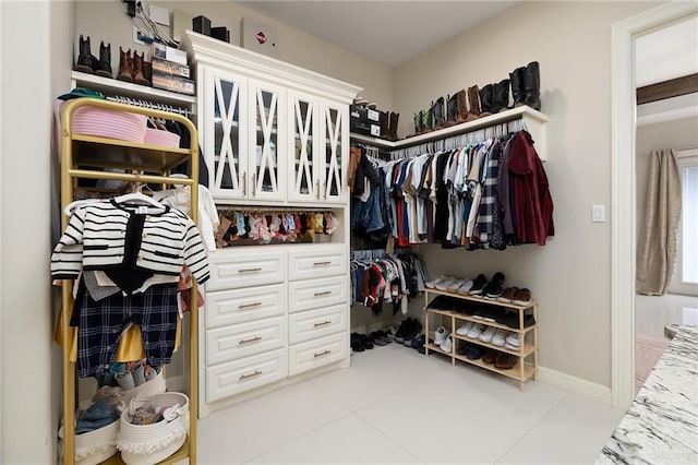 walk in closet with light tile patterned floors