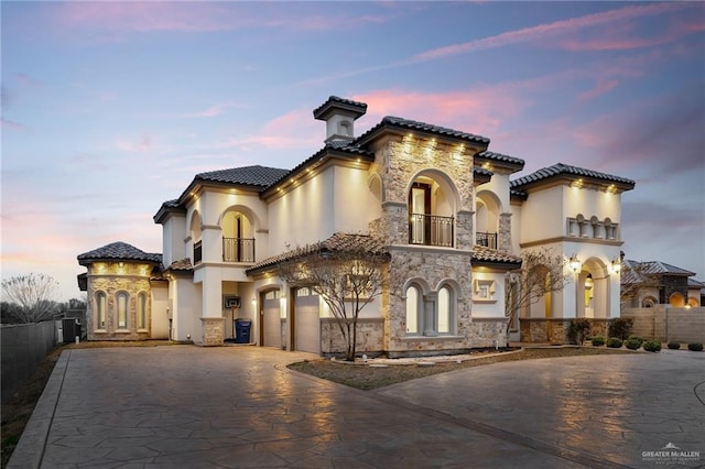 mediterranean / spanish home featuring a balcony and a garage