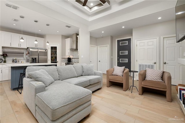 living room featuring a high ceiling and light hardwood / wood-style floors