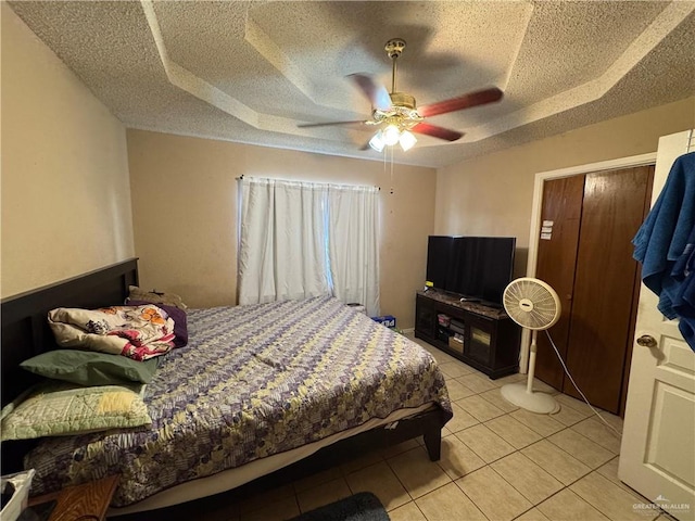 411 N Fir St, Pharr, TX 78577 - bedroom with a textured ceiling, a raised ceiling, light tile patterned floors, and a ceiling fan