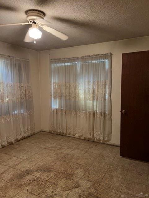 spare room with ceiling fan and a textured ceiling