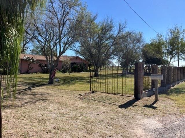 view of gate with a lawn