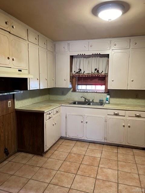 kitchen with white cabinetry, sink, and light tile patterned floors