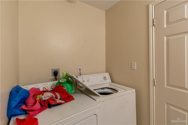 clothes washing area featuring separate washer and dryer