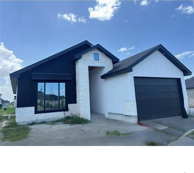 2217 N Venice Ave, Edinburg, TX 78542 - view of front facade with stone siding, a garage, and board and batten siding