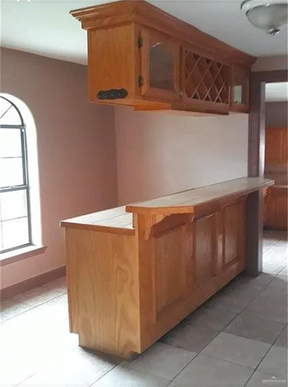 bar with tile patterned flooring and tile counters