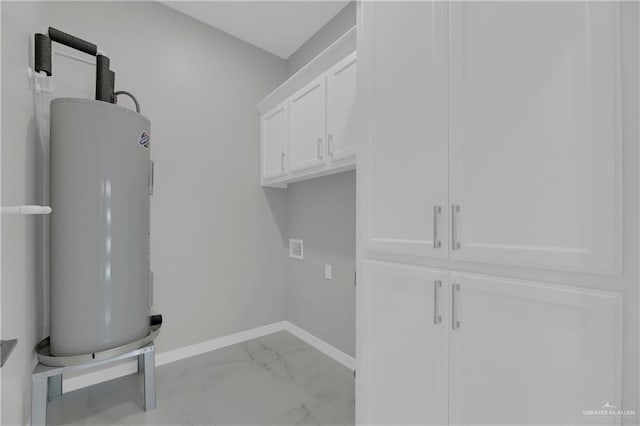 clothes washing area featuring water heater and cabinets