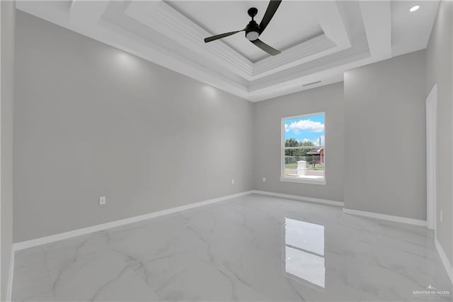 empty room featuring crown molding, ceiling fan, and a tray ceiling