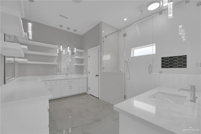 bathroom featuring a shower with shower door and sink