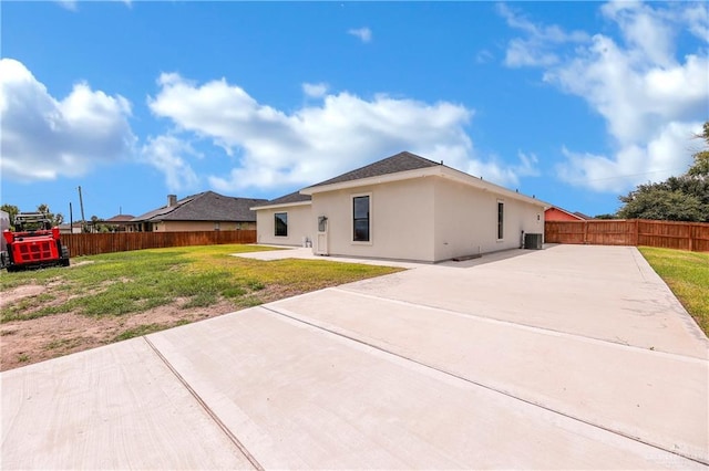 back of house featuring a lawn, a patio, and central air condition unit