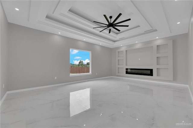 unfurnished living room with a tray ceiling, built in shelves, and ceiling fan