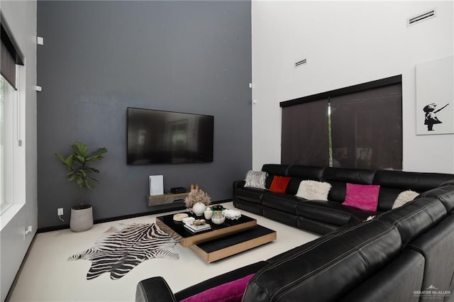 living room featuring carpet floors and a towering ceiling