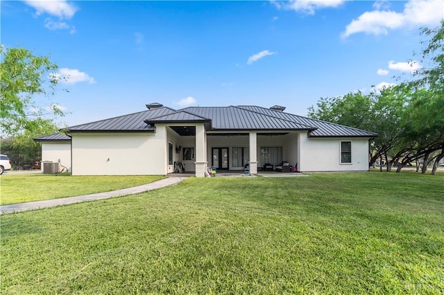 1412 E Mile 2nd Rd, Mission, TX 78574 - back of house featuring a standing seam roof, central AC unit, stucco siding, metal roof, and a yard