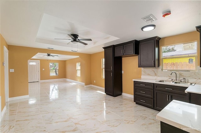 803 W Longoria St, Pharr, TX 78577 - kitchen featuring a sink, a raised ceiling, ceiling fan, light countertops, and baseboards