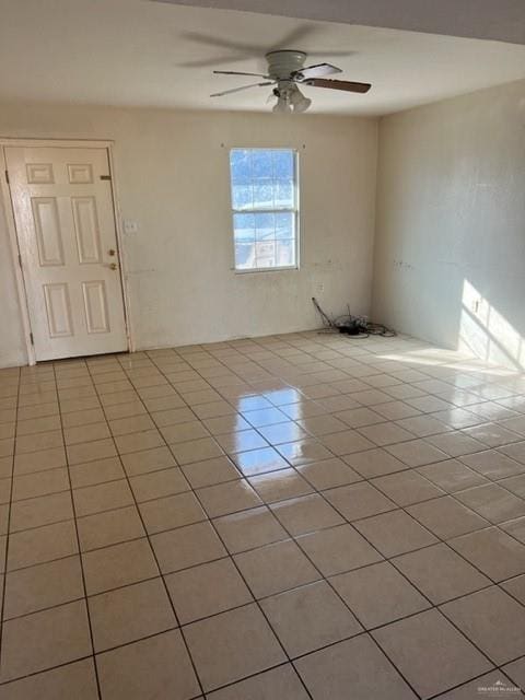 tiled spare room with ceiling fan