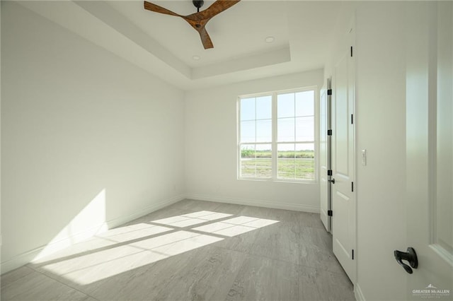 unfurnished room with a tray ceiling and ceiling fan