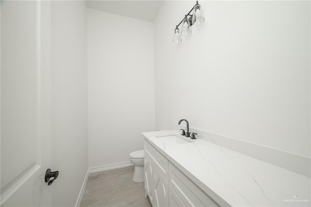 bathroom featuring vanity, wood-type flooring, and toilet