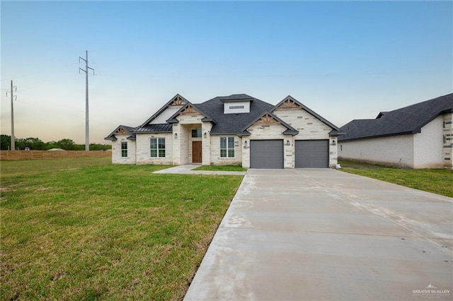 view of front of property with a garage and a lawn