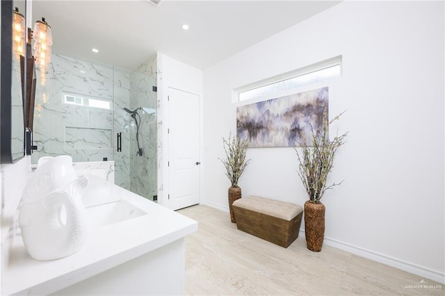 bathroom with wood-type flooring, vanity, and a shower with door