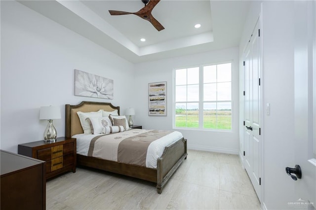 bedroom with a raised ceiling and ceiling fan