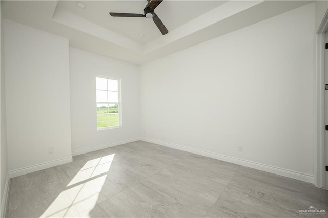 empty room with a tray ceiling and ceiling fan