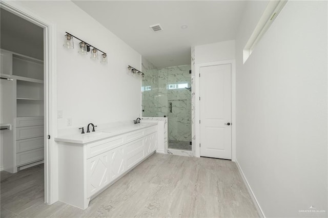 bathroom featuring wood-type flooring, vanity, and walk in shower