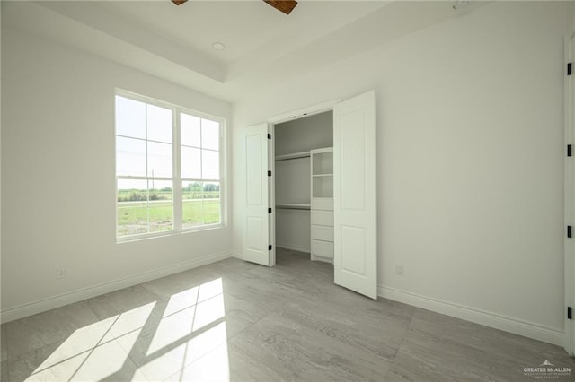 unfurnished bedroom featuring ceiling fan and a closet