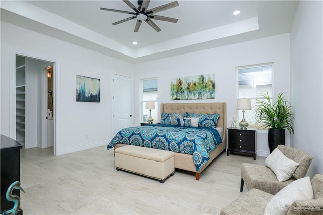 bedroom with a tray ceiling and ceiling fan