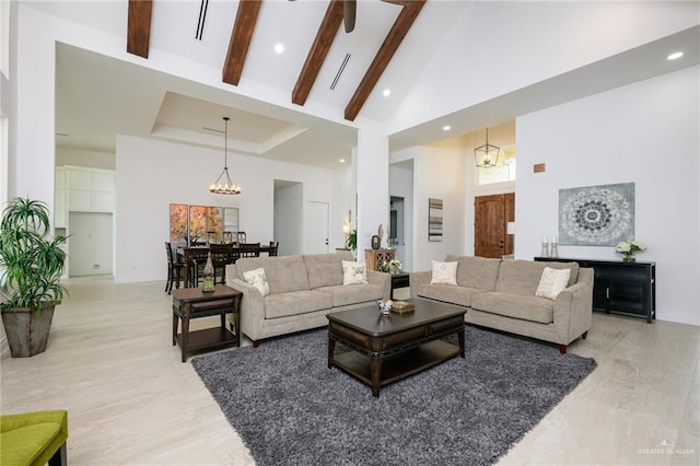 living room featuring beam ceiling, high vaulted ceiling, a chandelier, and light wood-type flooring